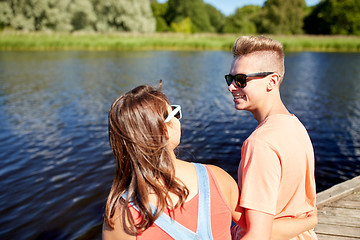 Image showing happy teenage couple sitting on river berth