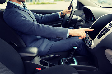 Image showing close up of young man in suit driving car