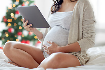 Image showing close up of pregnant woman with tablet pc at home