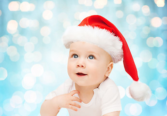 Image showing baby boy in christmas santa hat over blue lights