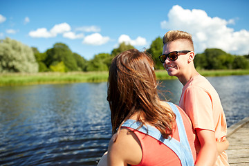 Image showing happy teenage couple sitting on river berth