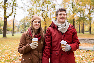 Image showing happy couple with coffee walking in autumn park