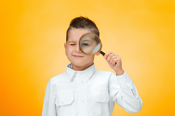 Image showing Little boy using magnifier looking close up