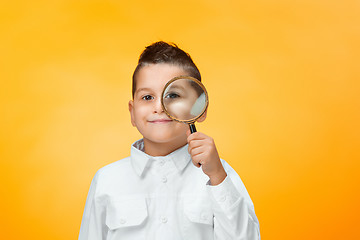 Image showing Little boy using magnifier looking close up