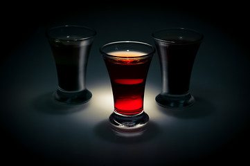 Image showing red and tow shot glass on a dark background in the spot light