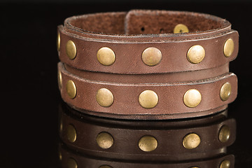 Image showing Brown leather bracelet isolated on a black