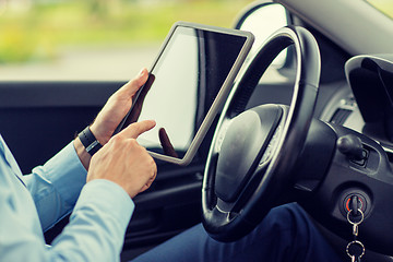 Image showing close up of young man with tablet pc driving car