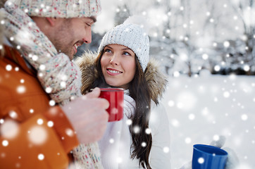 Image showing happy couple with tea cups over winter landscape