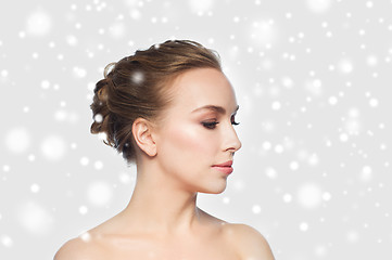 Image showing beautiful young woman face over snow