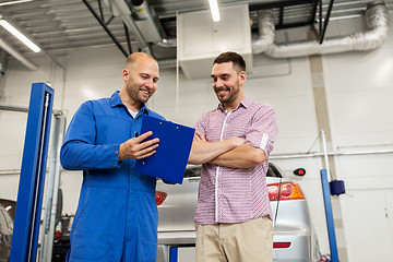 Image showing auto mechanic with clipboard and man at car shop