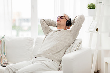 Image showing happy man in headphones listening to music at home