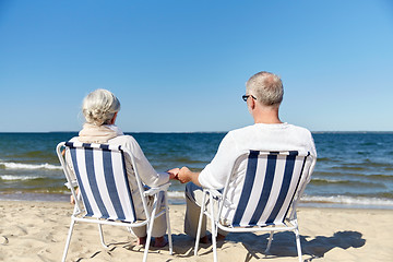 Image showing senior couple sitting on chairs at summer beach