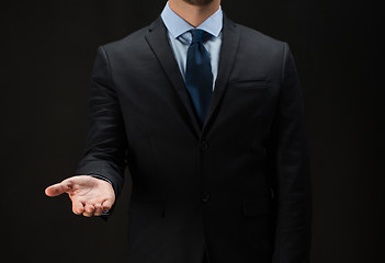 Image showing close up of businessman holding something on hand