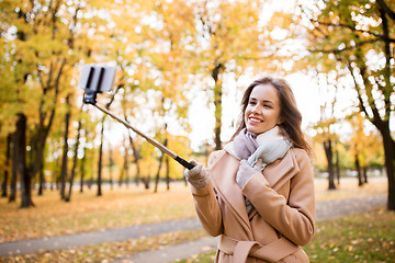 Image showing woman taking selfie by smartphone in autumn park