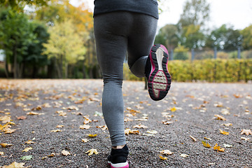 Image showing close up of young woman running in autumn park