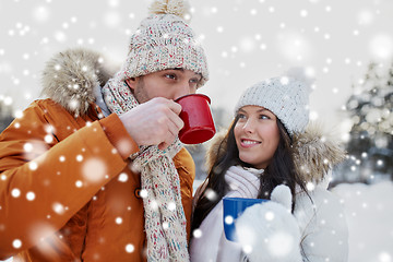 Image showing happy couple with tea cups over winter landscape