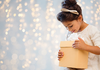 Image showing smiling little girl with gift box over lights