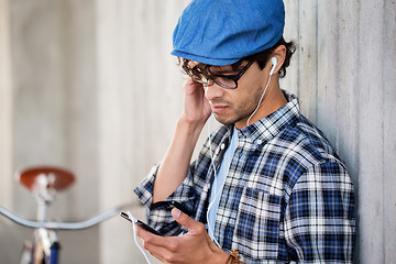 Image showing hipster man with earphones, smartphone and bike