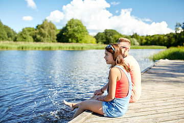 Image showing happy teenage couple sitting on river berth