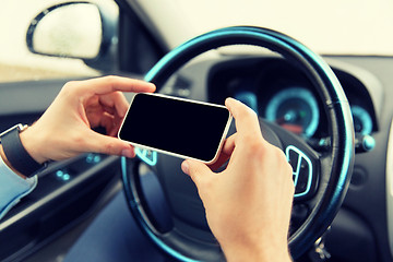 Image showing close up of man hand with smartphone driving car