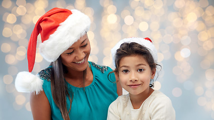 Image showing happy mother and little girl in santa hats