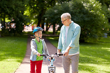 Image showing grandfather and boy with bicycle at summer park