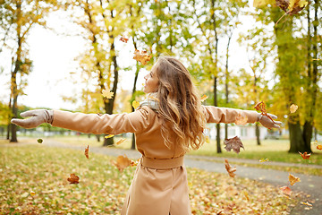 Image showing happy woman having fun with leaves in autumn park