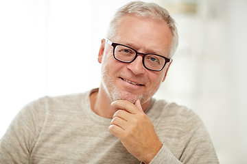 Image showing close up of smiling senior man in glasses thinking