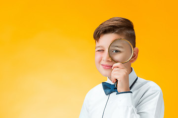 Image showing Little boy using magnifier looking close up