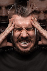 Image showing Stressed businessman with a headache over black