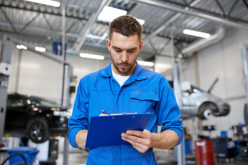Image showing auto mechanic man with clipboard at car workshop