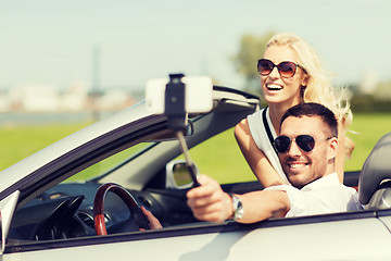 Image showing happy couple in car taking selfie with smartphone