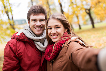 Image showing happy young couple taking selfie in autumn park