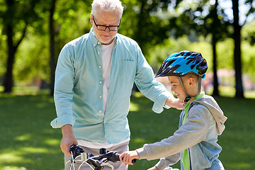 Image showing grandfather and boy with bicycle at summer park