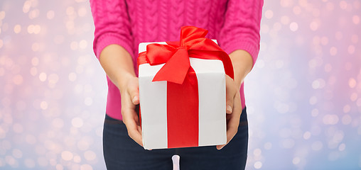 Image showing close up of woman in pink sweater holding gift box
