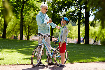 Image showing grandfather and boy with bicycle at summer park