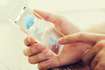 Image showing close up of male hand with weather cast smartphone