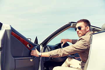 Image showing happy man opening door of cabriolet car outdoors