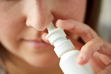 Image showing close up of sick woman using nasal spray