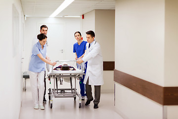 Image showing medics with woman on hospital gurney at emergency