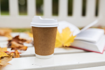 Image showing coffee drink in paper cup on bench at autumn park