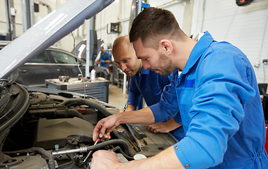 Image showing mechanic men with wrench repairing car at workshop