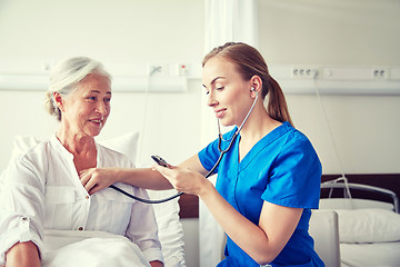 Image showing nurse with stethoscope and senior woman at clinic