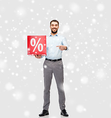 Image showing smiling man with red percentage sign over snow