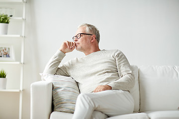 Image showing  senior man sitting on sofa at home and thinking