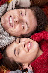 Image showing close up of happy couple lying on autumn leaves