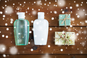 Image showing handmade soap bars and lotion bottles on wood