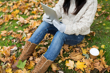 Image showing woman with tablet pc and coffee in autumn park