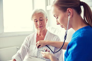 Image showing nurse with stethoscope and senior woman at clinic