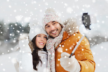 Image showing happy couple taking selfie by smartphone in winter